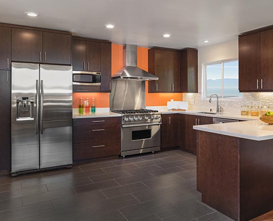 Clean modern kitchen with brown cabinets and hardwood flooring after clogged drain overflow cleanup service