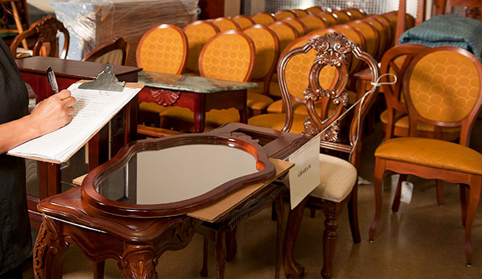 Restoration technician cataloging restored furniture and personal contents