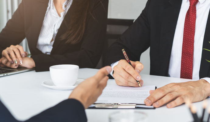 Business owner reviewing and signing commercial disaster insurance claim documents