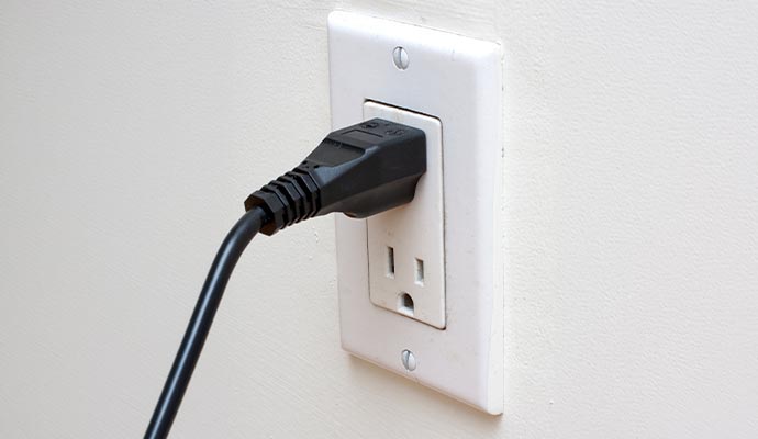 Electrical wall outlet with plugged power cord