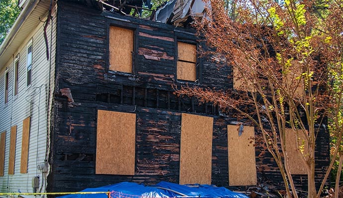 Charred residential house secured with emergency plywood board-up service