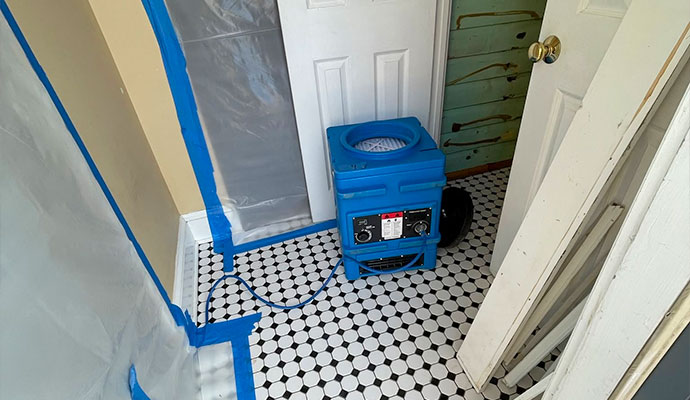 Commercial drying equipment and plastic containment barrier in a home hallway