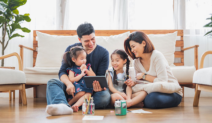 Happy family using tablet in a living room.
