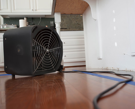 Industrial air mover fan drying a hardwood floor