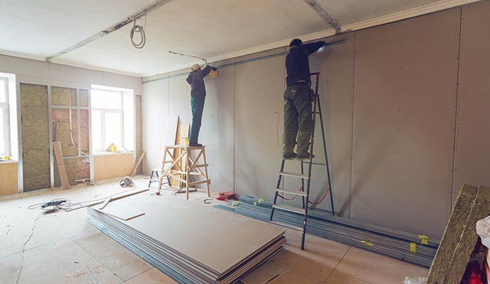 Contractors repairing interior walls during residential renovation