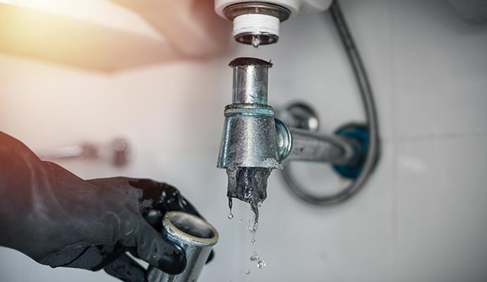 Leaking drain pipe under sink during plumbing repair
