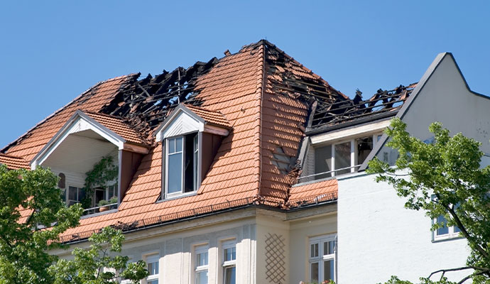 Residential building roof with severe fire and structural damage