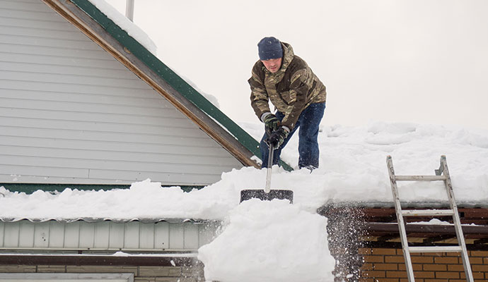 A person is cleaning snow from roof