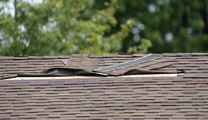 Damaged shingles on roof due to wind damage
