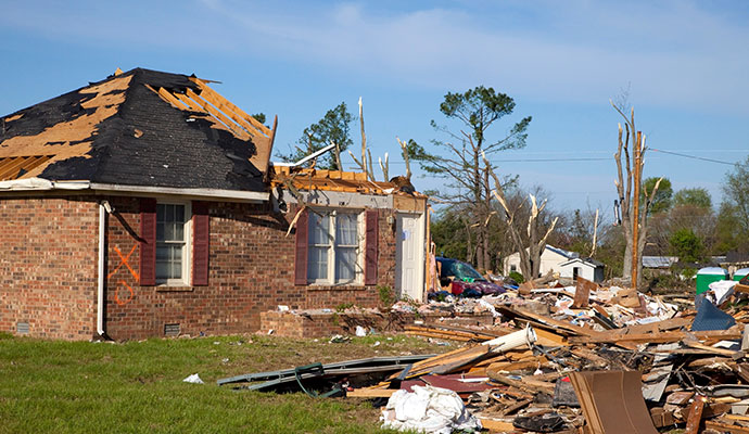 Storm damaged brick house with debris