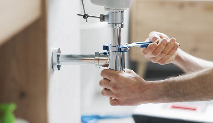 Plumber installing sink drain pipe